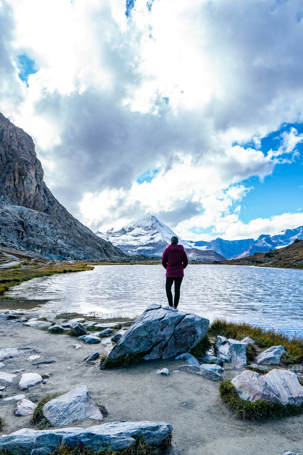 a person standing on a rock near a body of water