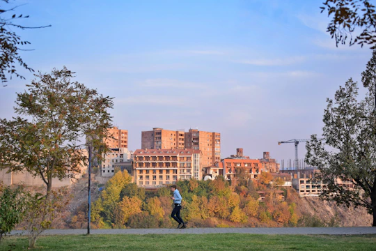 A person jogging in the park while checking their health stats on a vibrant mobile app.