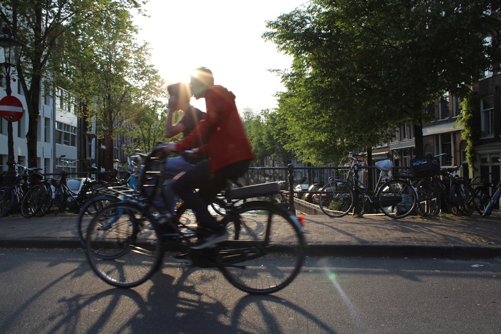 a man riding a bike down a street next to tall buildings