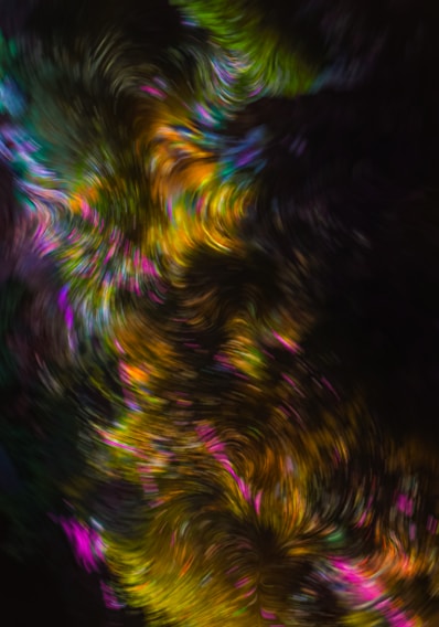 A vibrant kaleidoscope pattern swirling with rich blues, purples, and golds, glowing softly against a dark background.