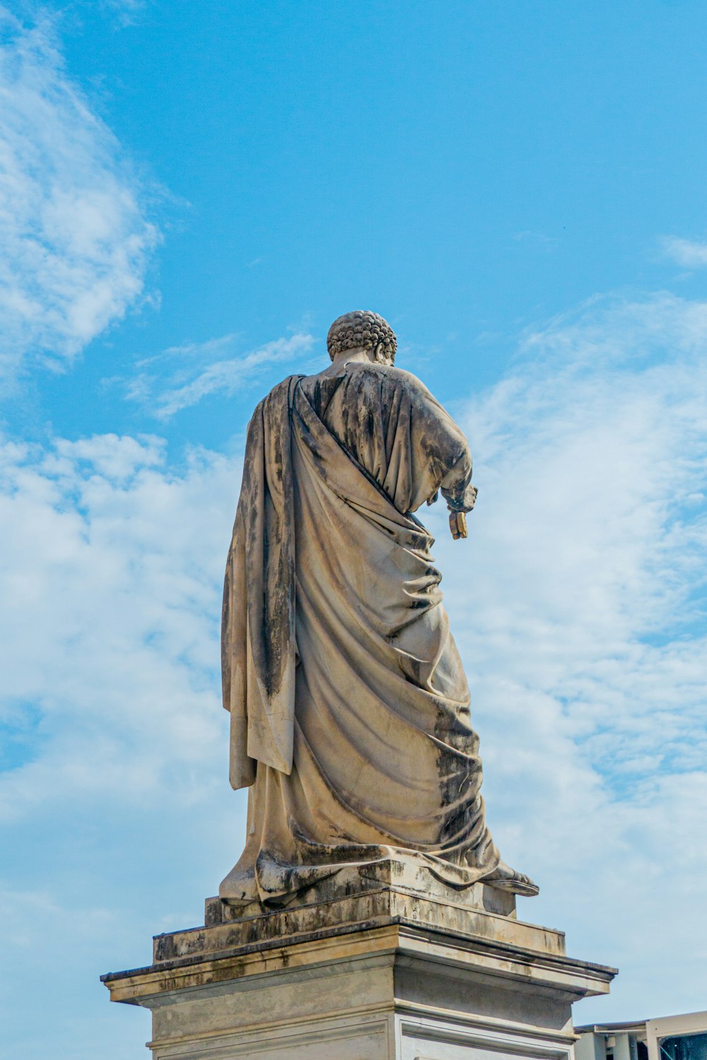 a statue of a man holding a cross on top of a building