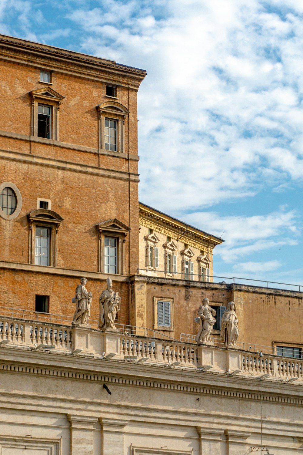 a tall building with statues on the top of it