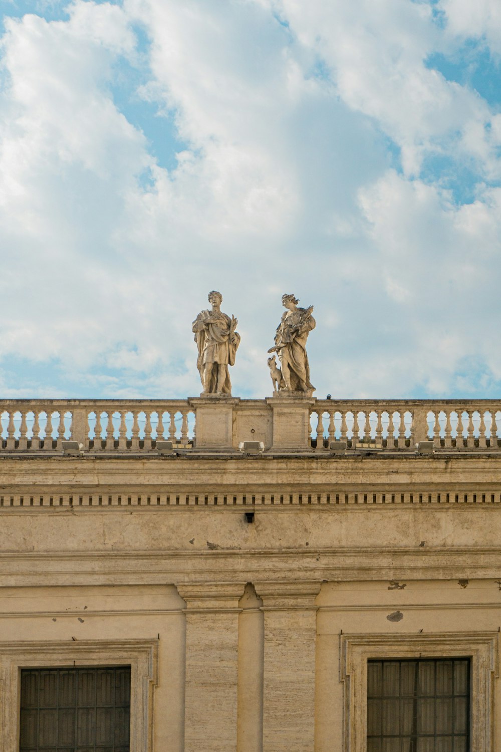 two statues on the top of a building