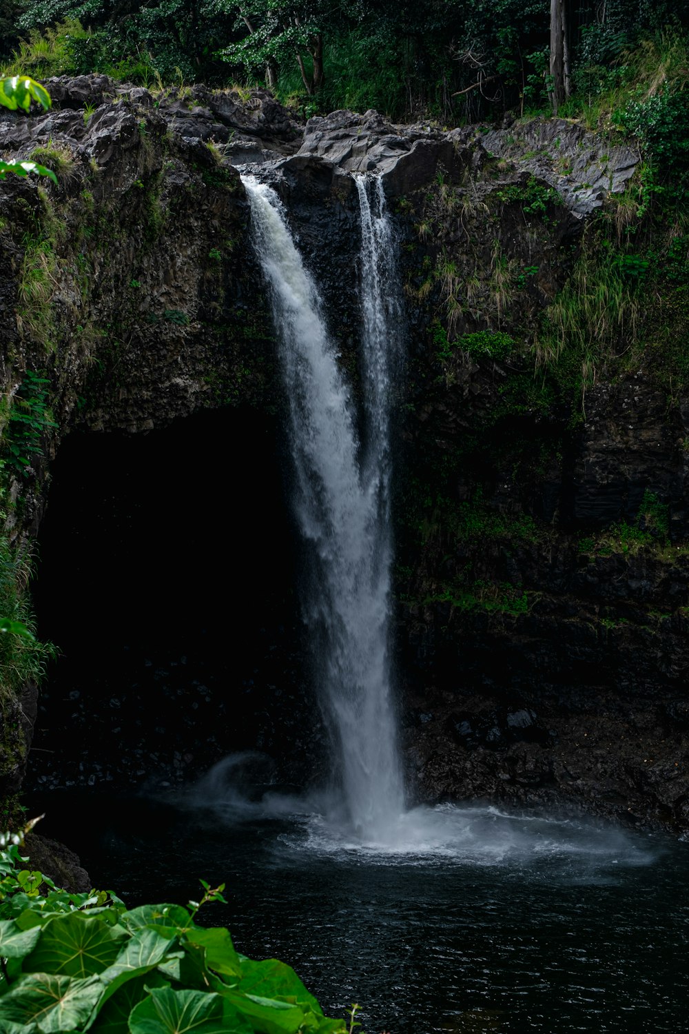 a large waterfall in the middle of a forest