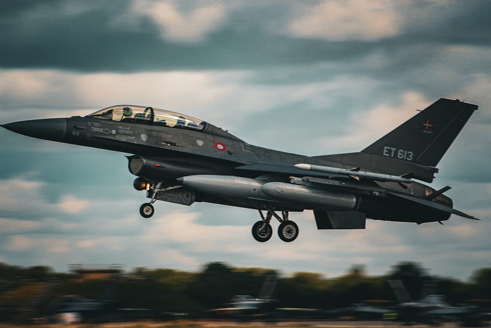 a fighter jet flying through a cloudy sky