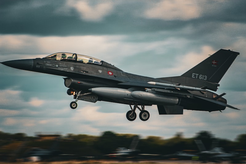 A fighter jet flying through a cloudy sky