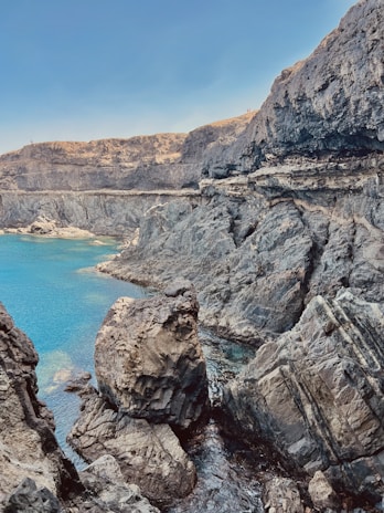 The dramatic coastline of Aden with turquoise waters meeting rugged cliffs and historic forts.