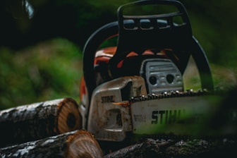 a chainsaw sitting on top of a pile of logs