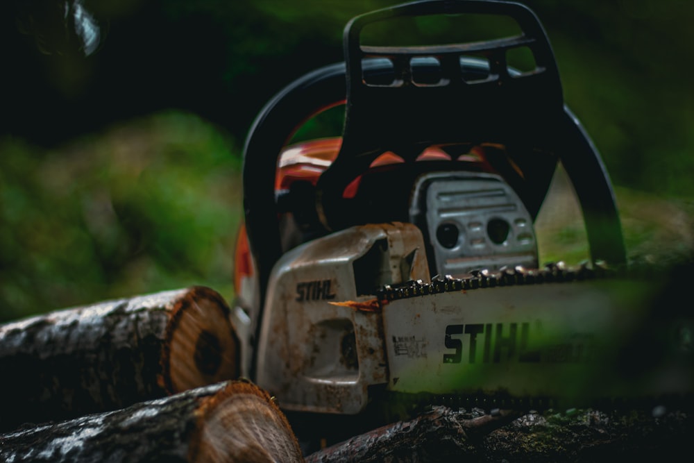 a chainsaw sitting on top of a pile of logs