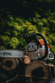 a chainsaw sitting on top of a pile of logs