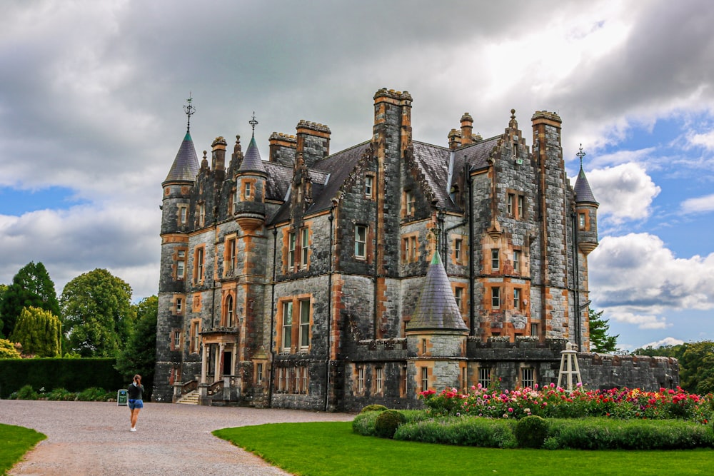 a large castle like building sitting on top of a lush green field