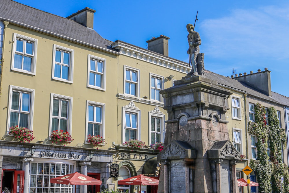 a statue in front of a building with many windows