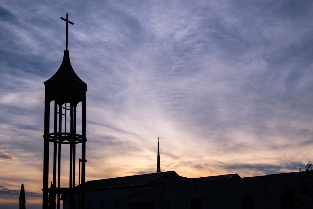 a tall tower with a cross on top of it