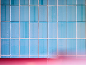 A freshly installed blue mosaic tile backsplash brightening a kitchen wall.