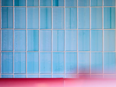 A freshly installed blue mosaic tile backsplash brightening a kitchen wall.
