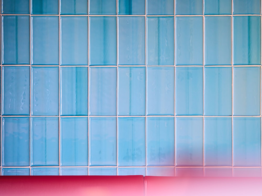 a blue and pink tiled wall with a red corner