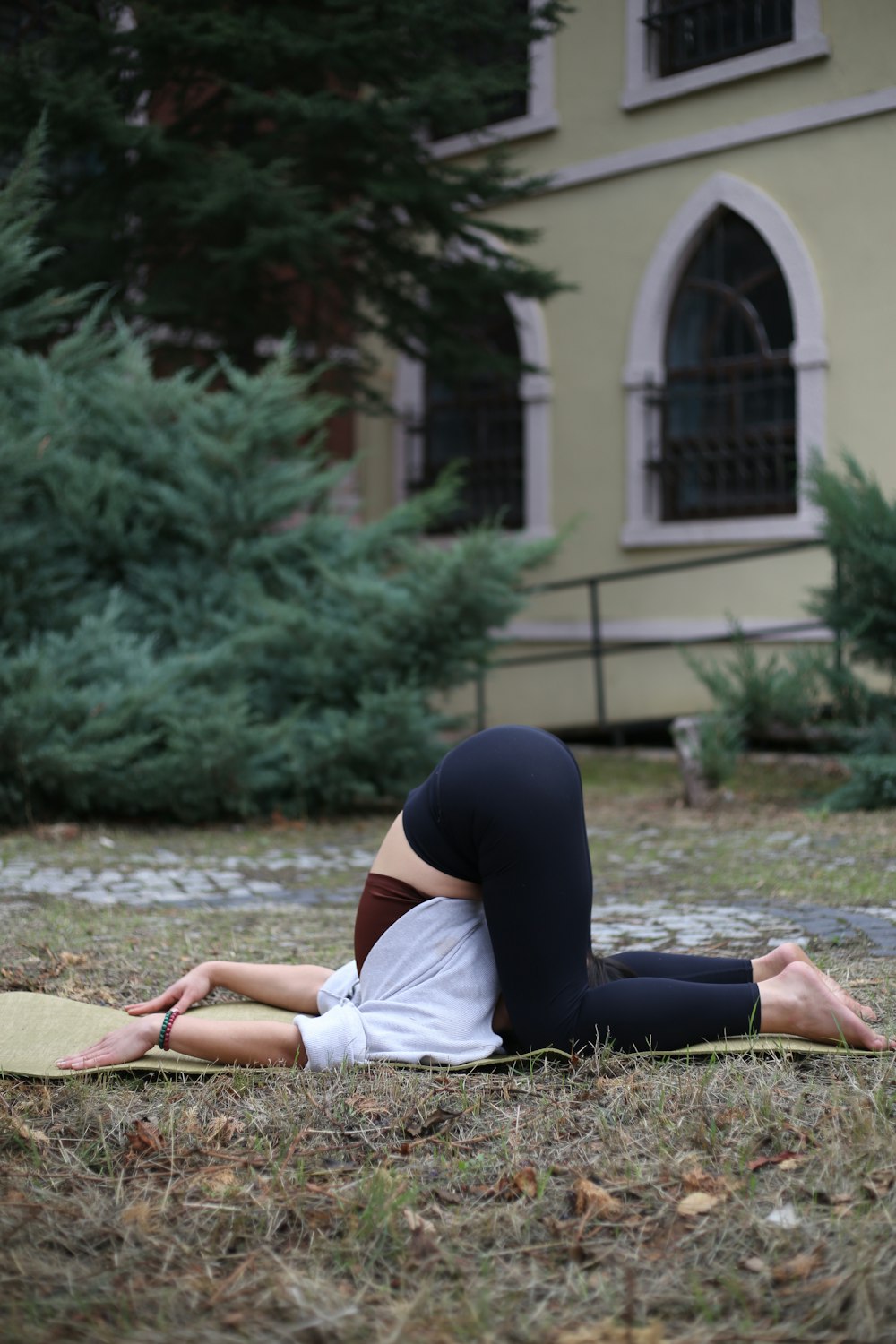 a woman laying on a yoga mat in front of a building
