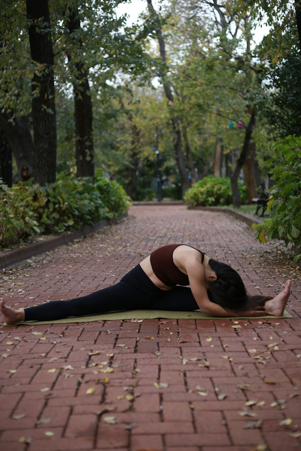 a woman is doing a yoga pose on a brick path