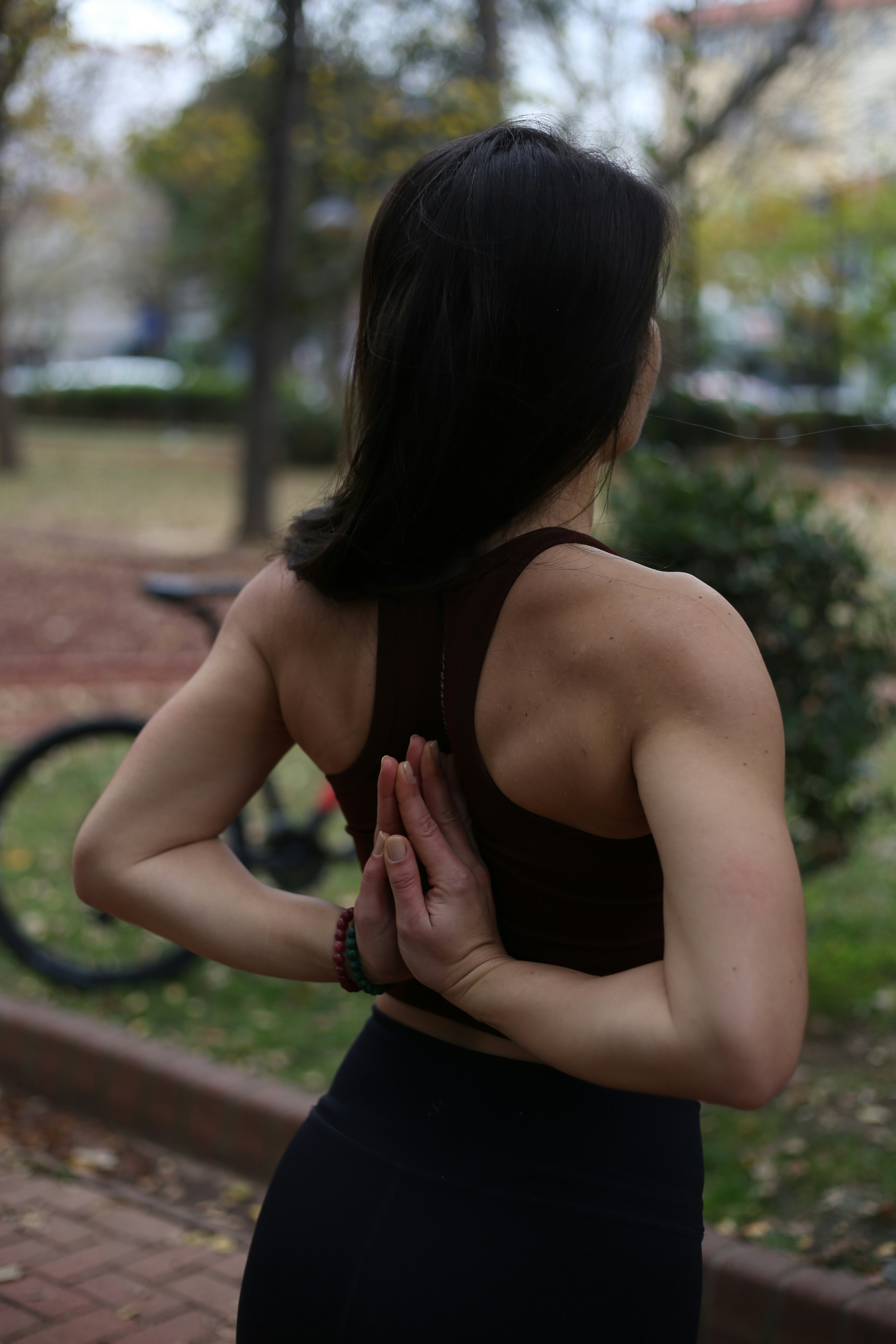 公園に手を合わせて立つ女性