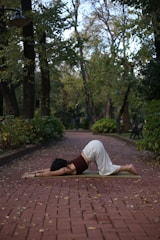 a woman practicing yoga on a brick path