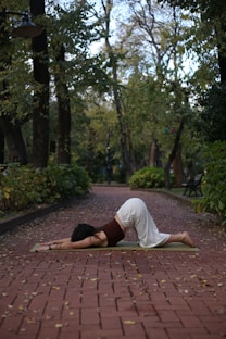 a woman practicing yoga on a brick path
