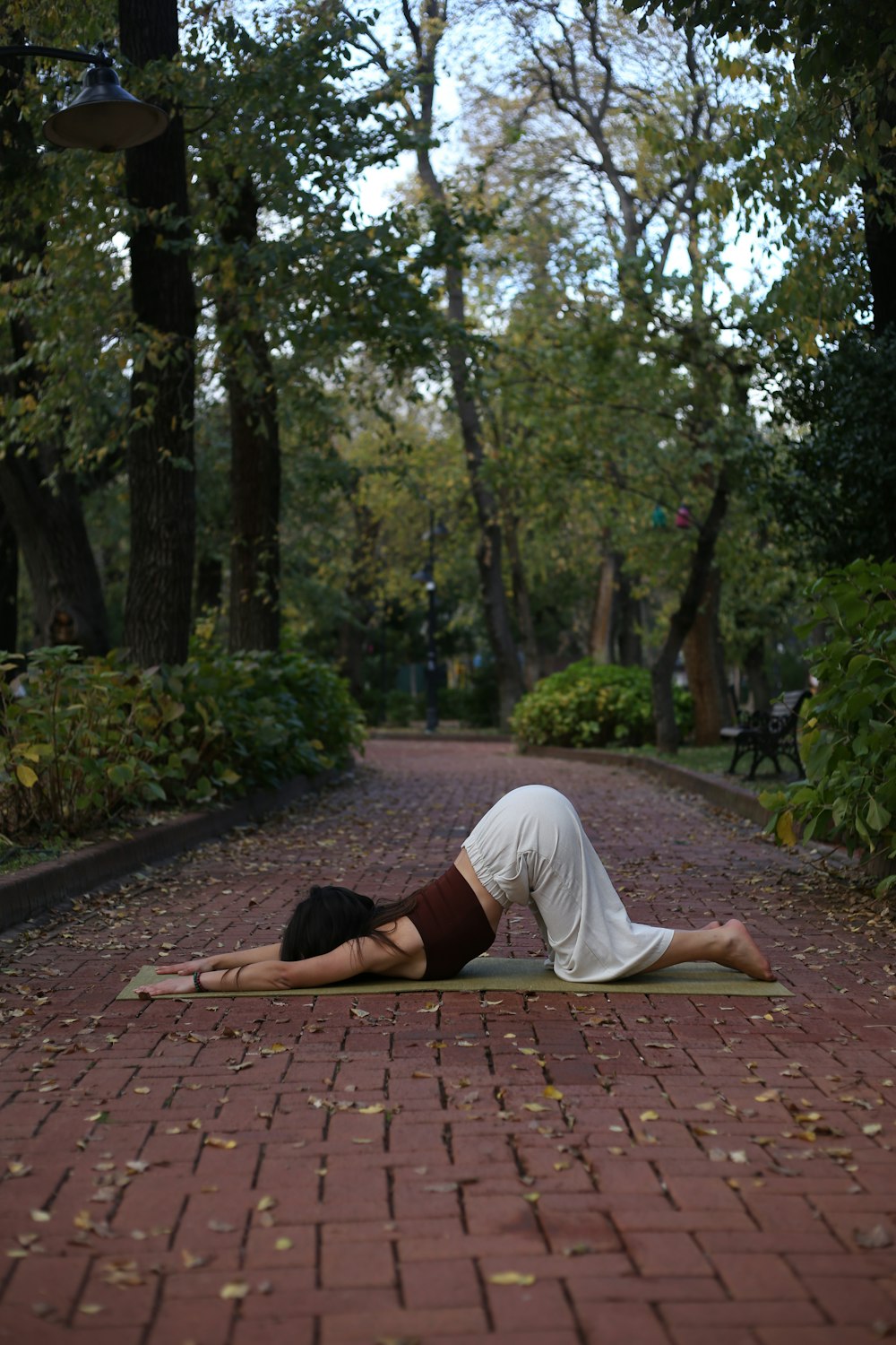 a woman laying on her back on a brick path