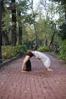 a woman is doing a handstand on a brick path