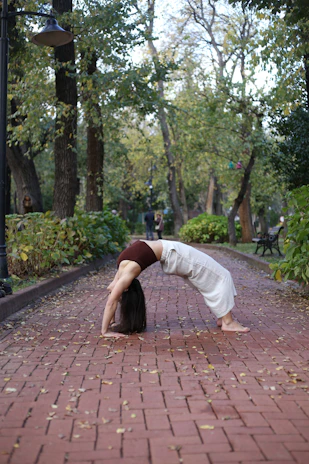 a woman is doing a handstand on a brick path
