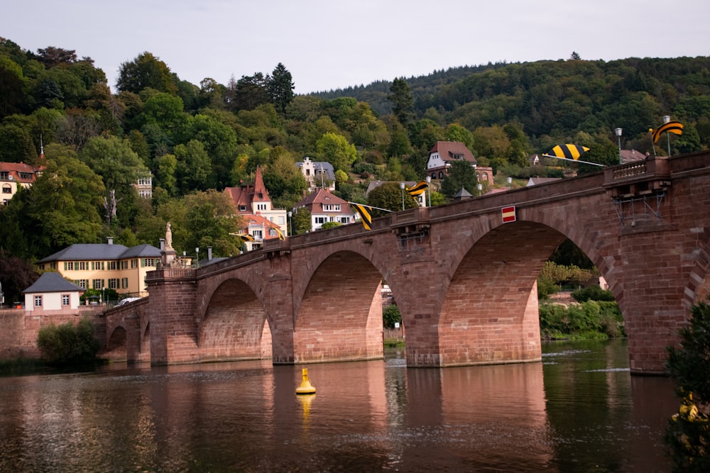 a bridge over a body of water with a town in the background