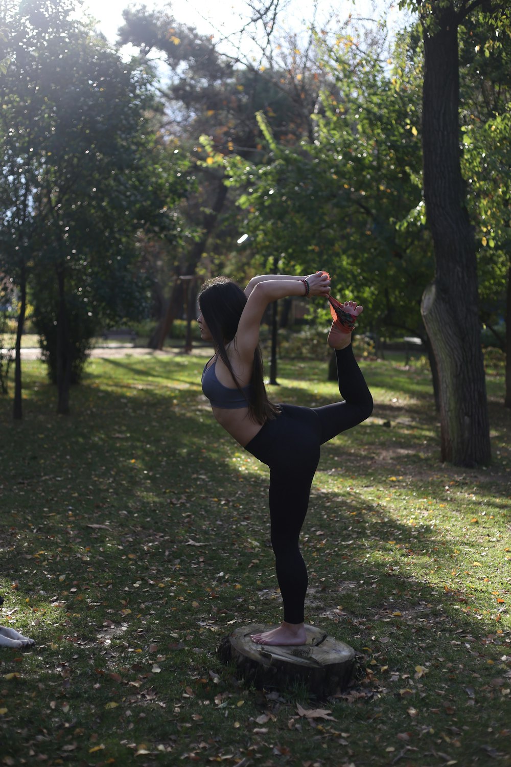 a woman doing a yoga pose in a park