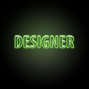 Neon green text with the word 'DESIGNER' on a dark background, glowing brightly with a soft green hue around the letters.