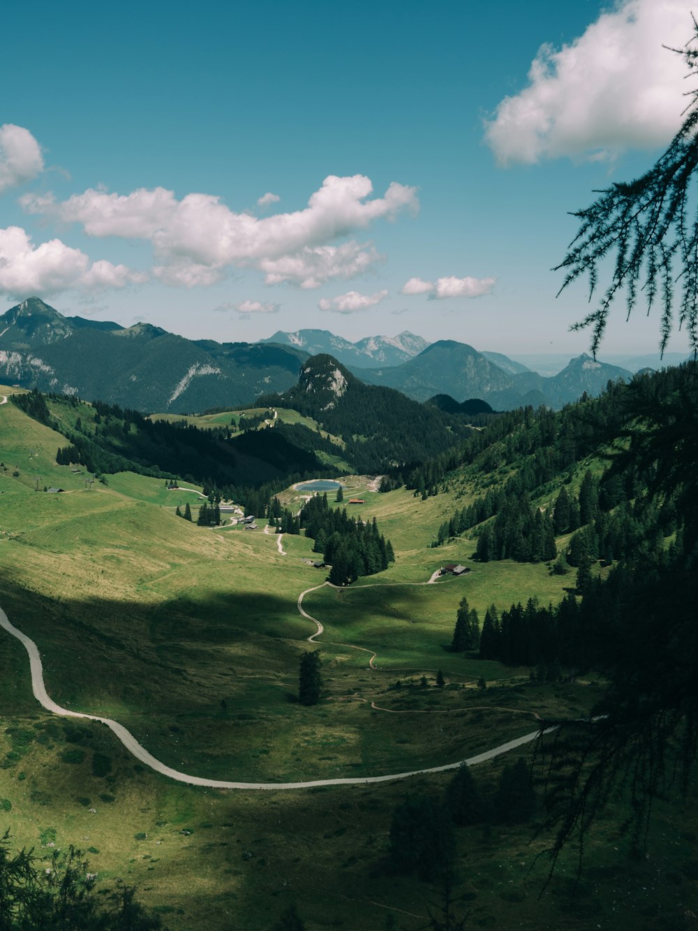 a winding road in the middle of a lush green valley