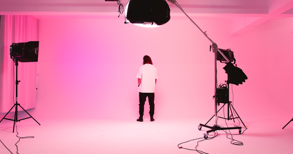 a person standing in front of a pink light