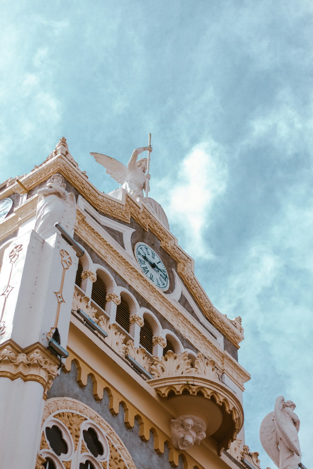 a clock tower with statues on top of it