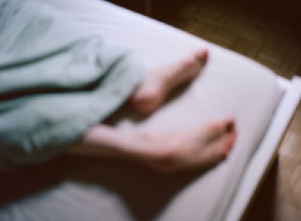 a person laying on a bed with their feet propped up