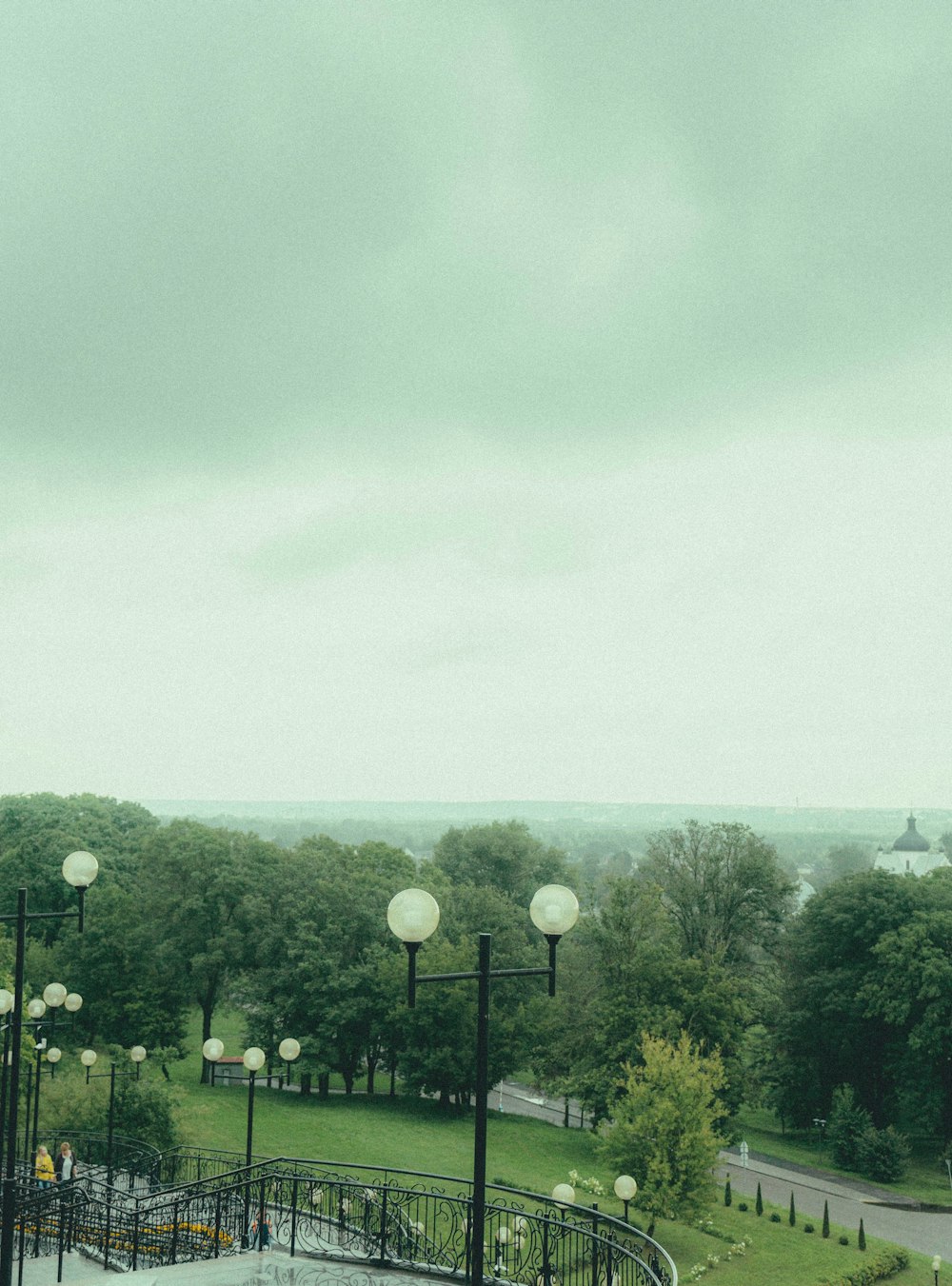 a view of a park with a clock tower in the distance