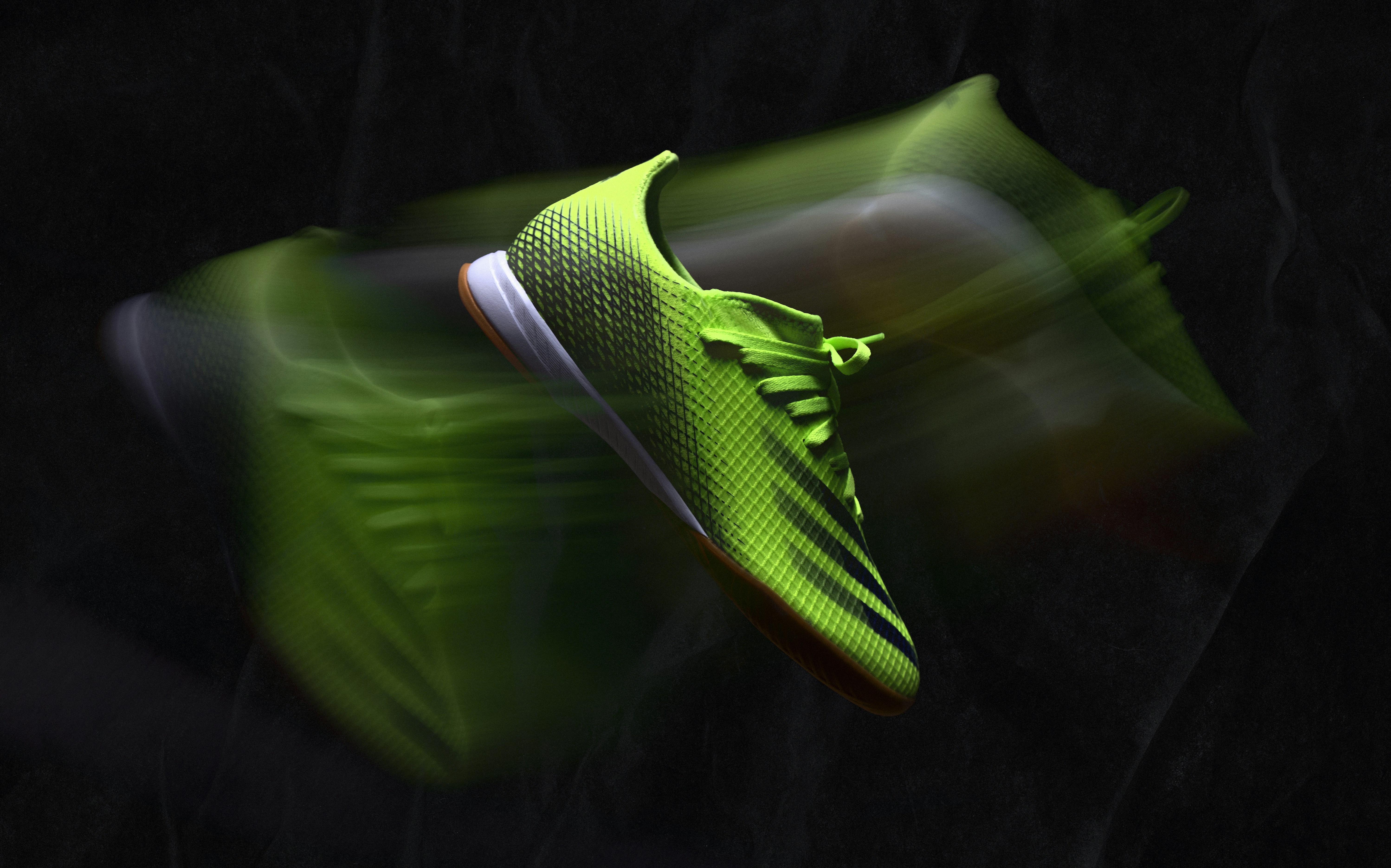 a pair of neon green shoes flying through the air