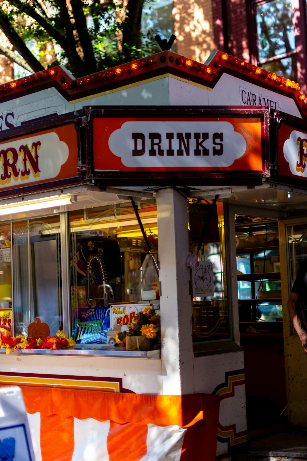 a food stand on a city street with people walking by