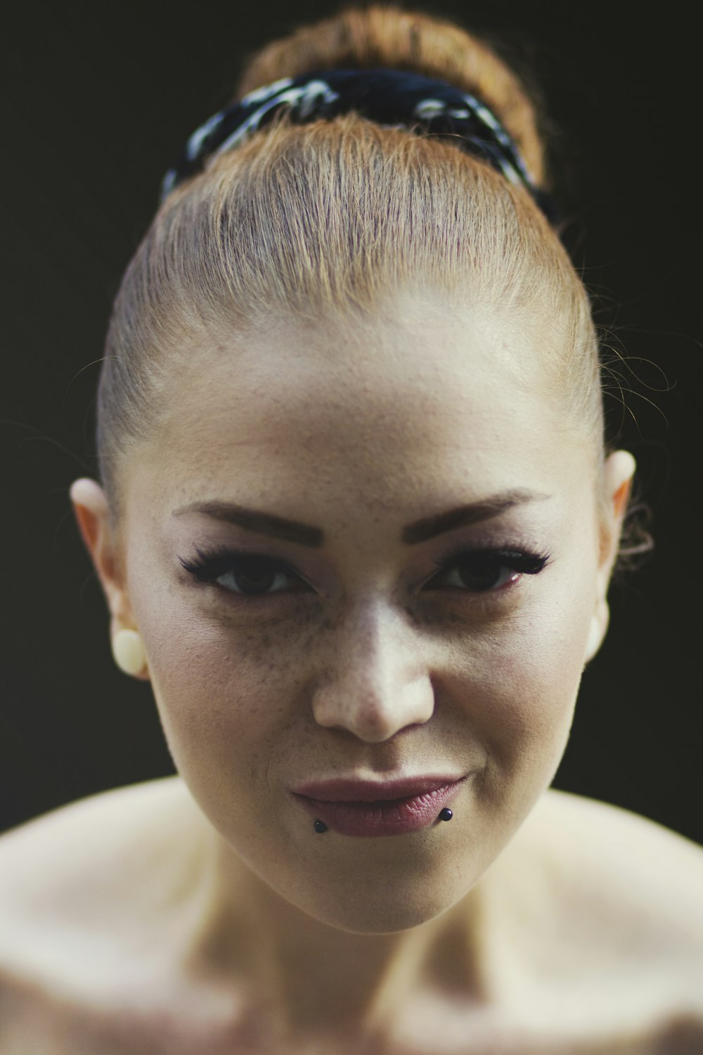 a woman with black makeup and piercings on her face