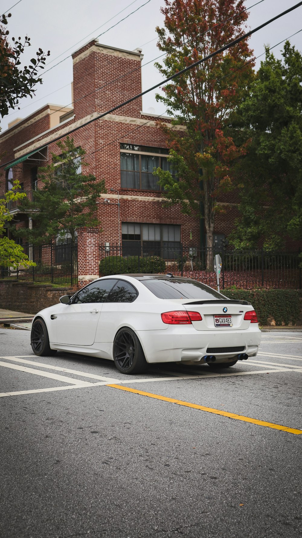 a white car parked in front of a brick building