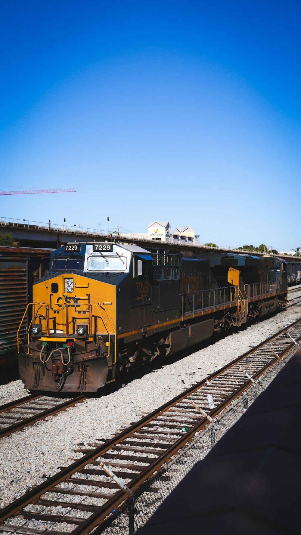 Ein gelb-schwarzer Zug, der die Bahngleise hinunterfährt