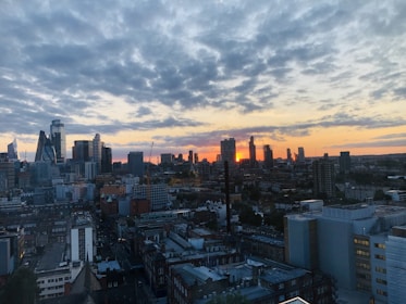 A city skyline at sunset highlighting diverse residential and commercial buildings.