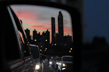 Reflection of city skyline on a freshly detailed luxury coupe’s hood at dusk.
