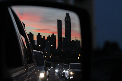 Reflection of city skyline on a freshly detailed luxury coupe’s hood at dusk.