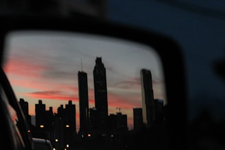 A scenic view of a city skyline at dusk from a car window.