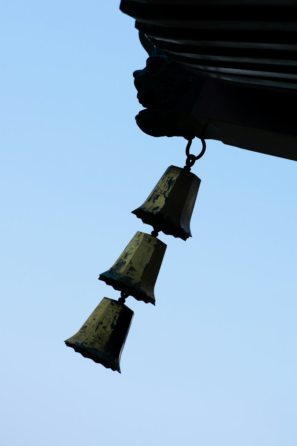 a group of bells hanging from the side of a building