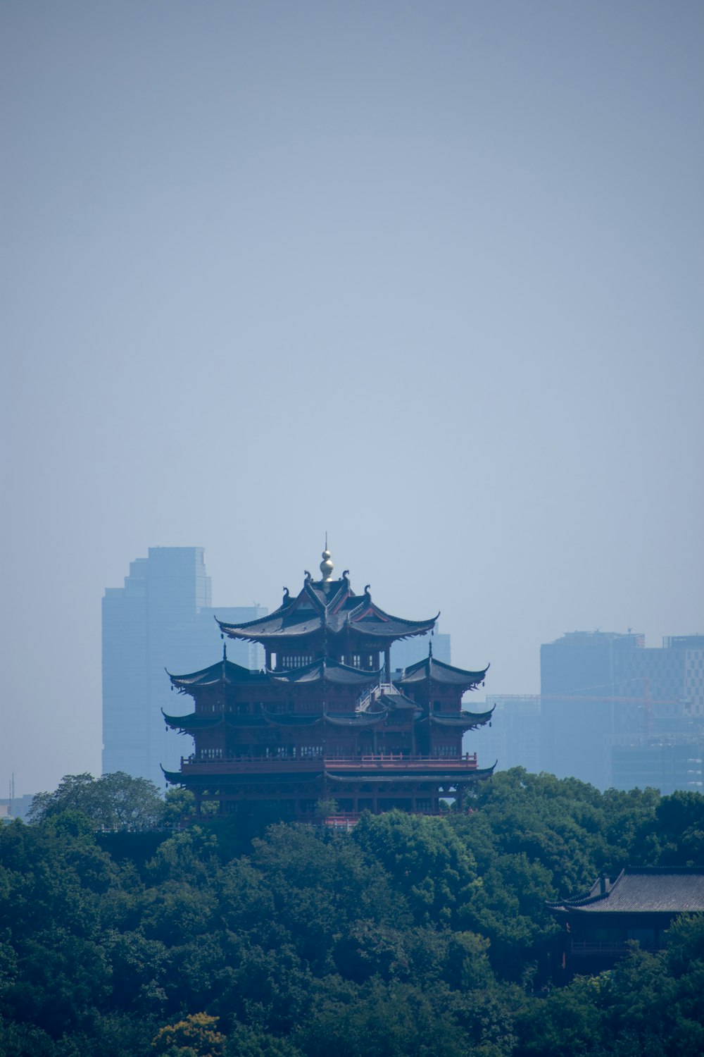 a tall building sitting on top of a lush green hillside