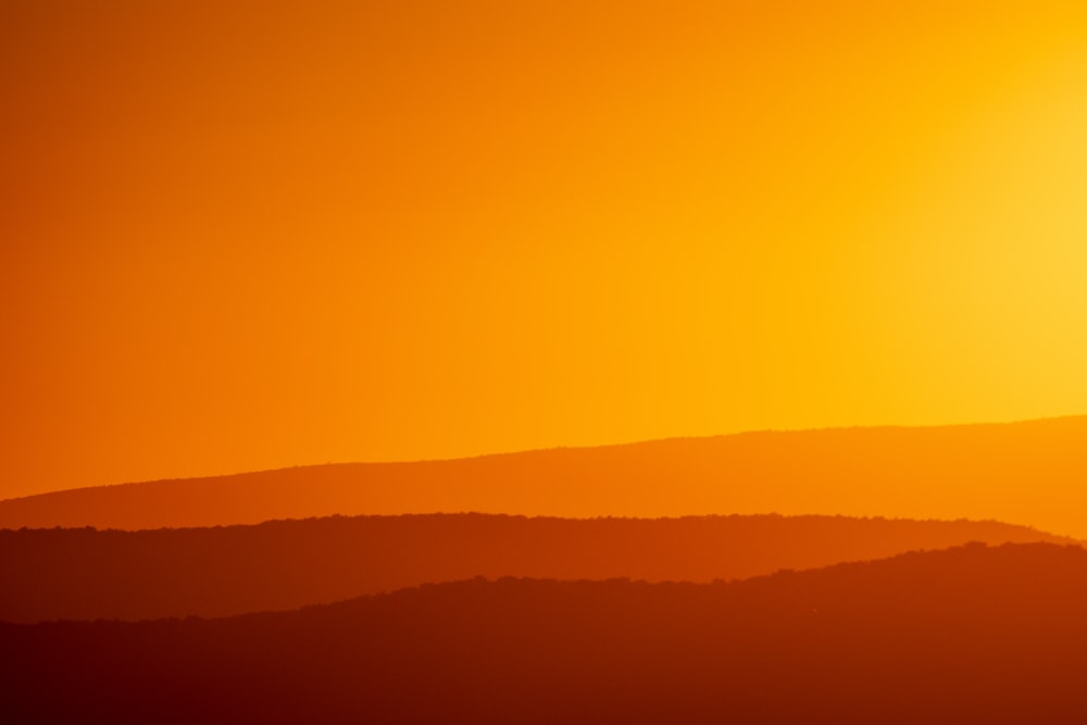 Le soleil se couche sur une chaîne de montagnes