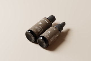 Two brown bottles with minimalistic labels are positioned on a neutral background. One bottle has a dropper top while the other has a regular cap. The label text includes the words 'Bottle Duo' and features a QR code.