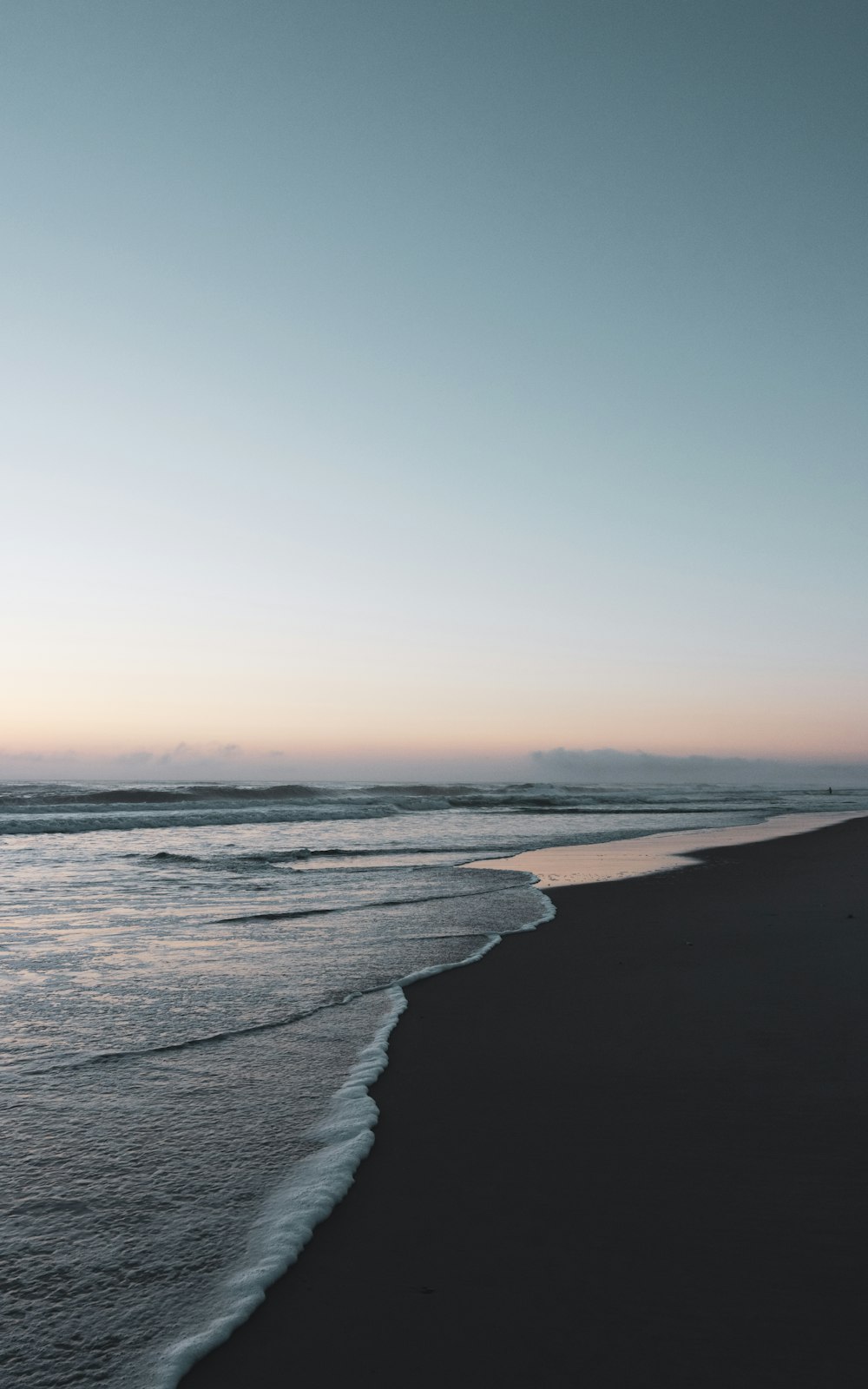 a person walking along a beach near the ocean